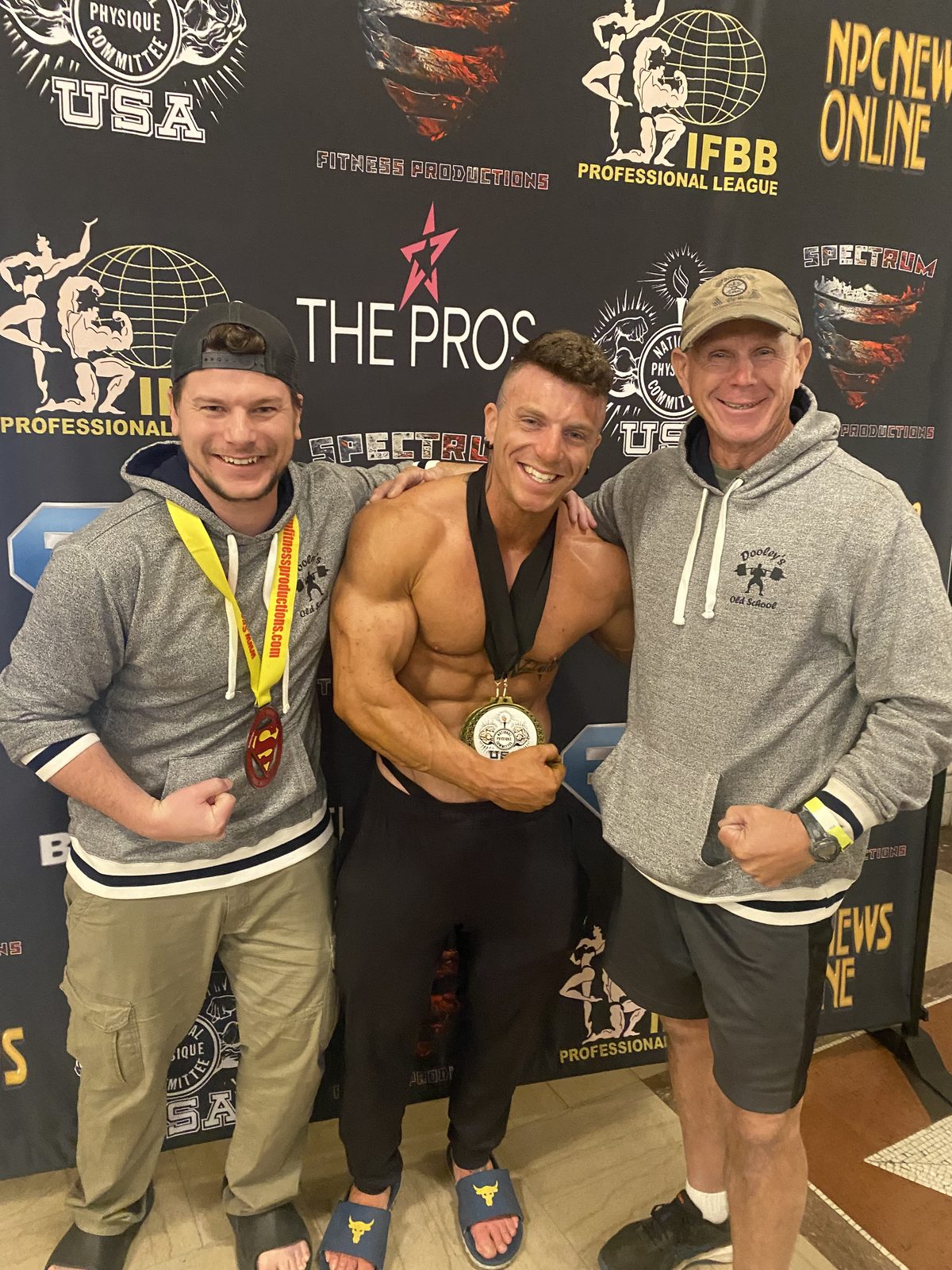 Lance celebrating a competition medal with Jim and a friend