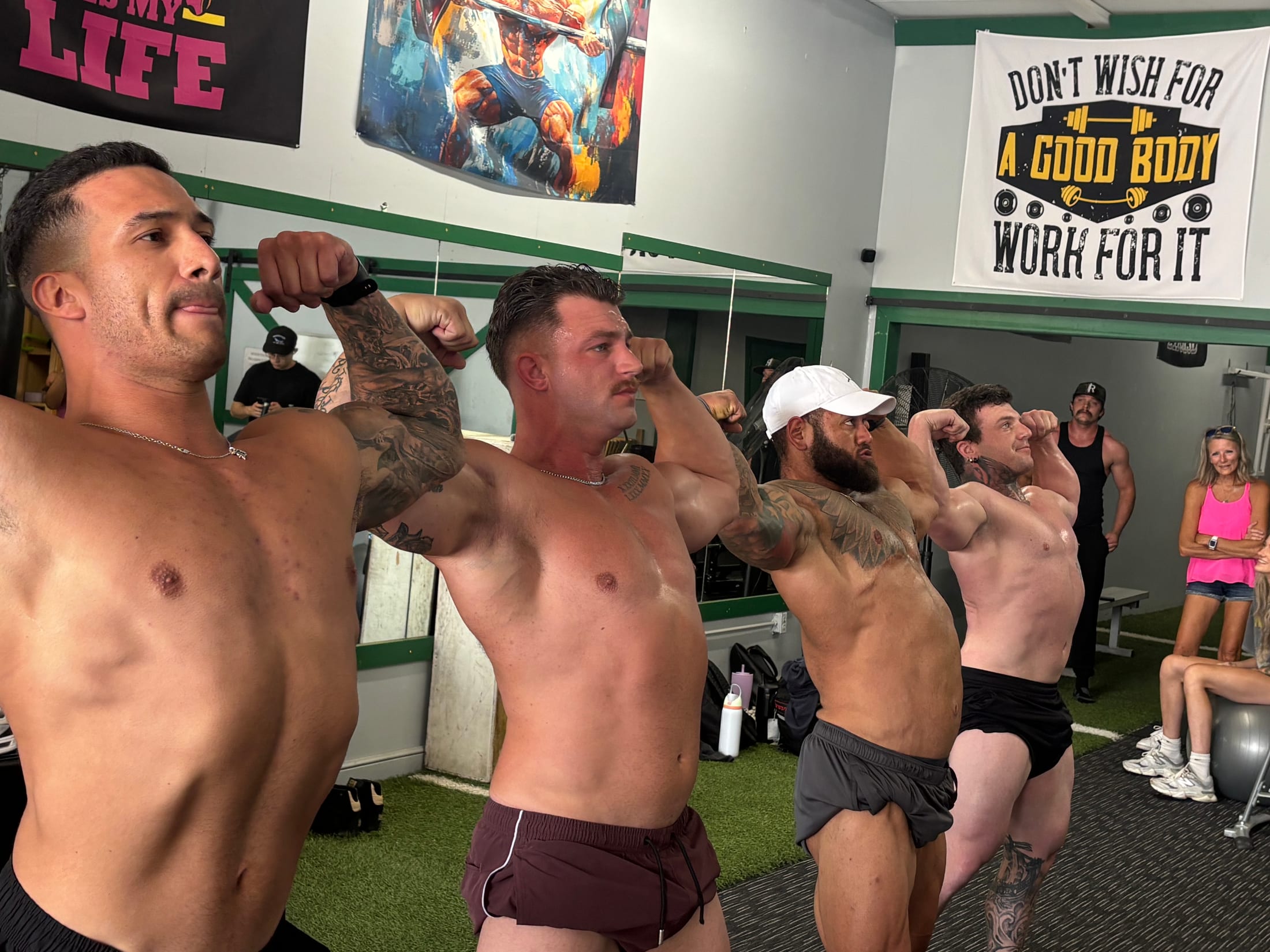Members practicing bodybuilding poses together